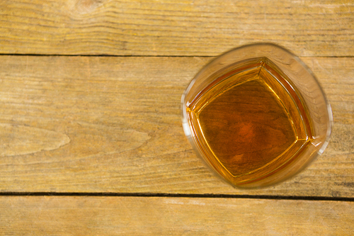 Close-up of glass of whisky on wooden table