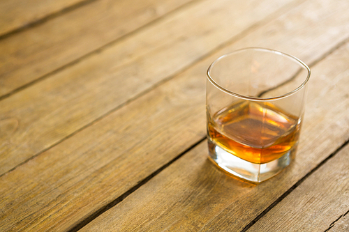 Close-up of glass of whisky on wooden table