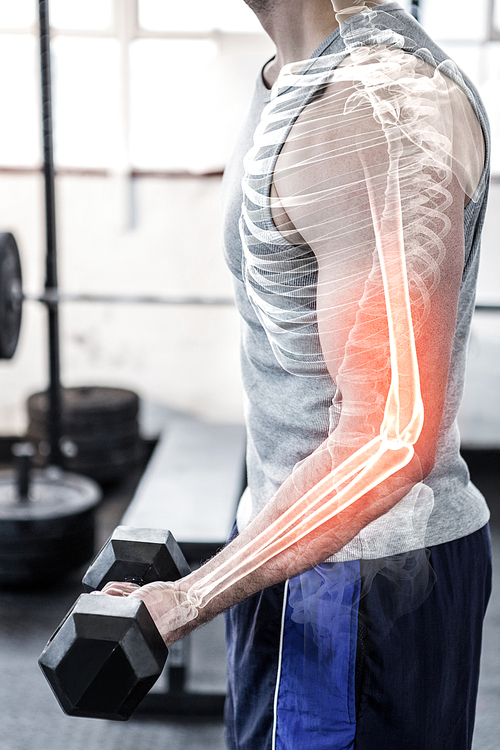 Digital composite of highlighted arm of strong man lifting weights at gym