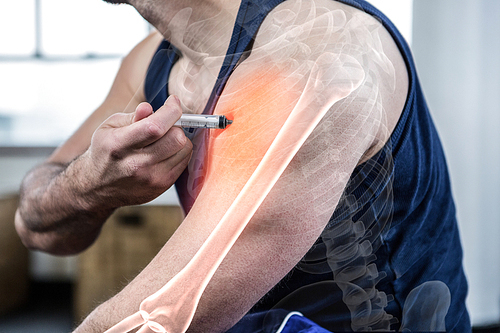 Digital composite of highlighted arm of strong man injecting anabolic steroid at gym