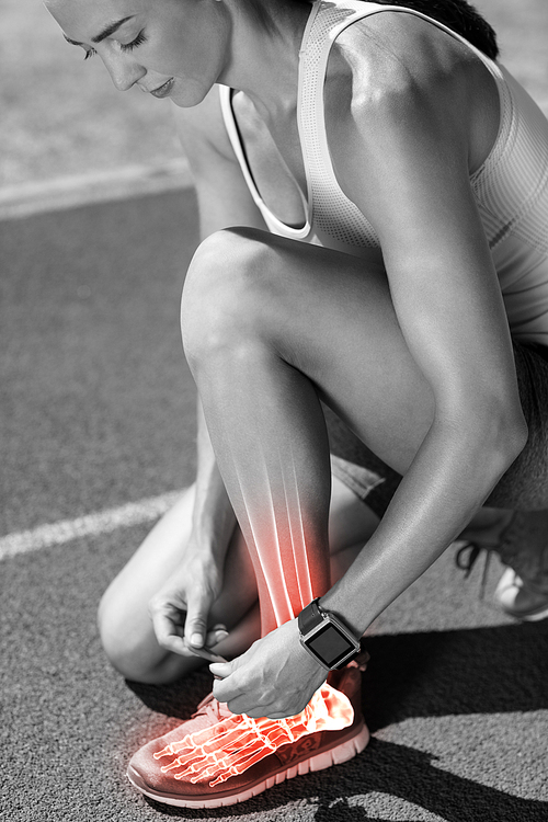 Digital composite of highlighted bones of woman tying shoe lace on race track