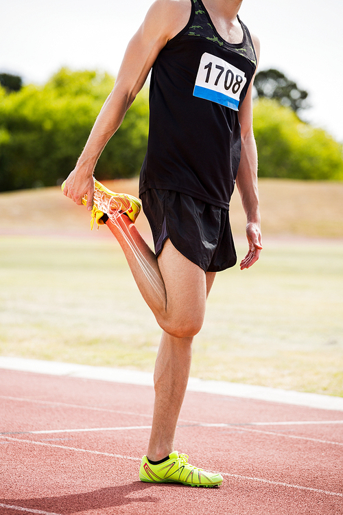 Digital composite of highlighted bones of athlete man stretching on race track