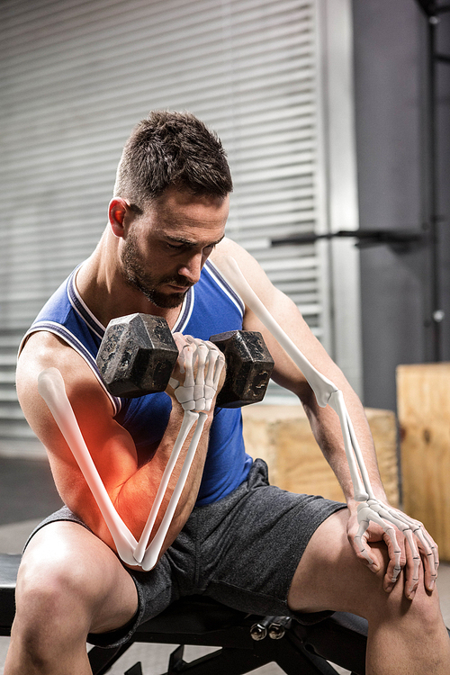 Male athlete doing excercise with dumbbells at gym