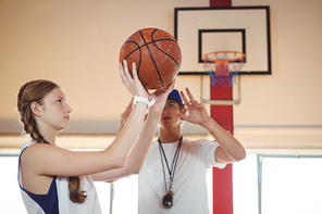 Coach advising female basketball player while practicing in court