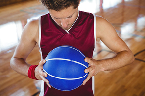 High angle view of male basketball player holding ball while standing in court