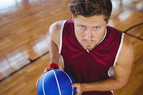 High angle portrait of basketball player holding ball while practicing in court