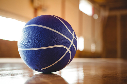 Blue basketball on hardwood floor in court