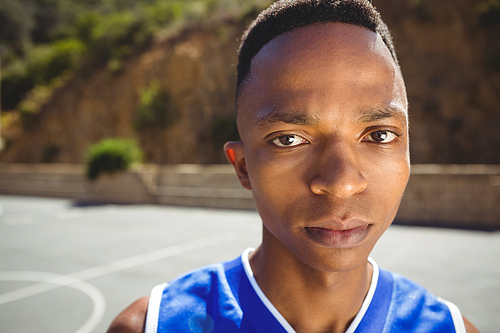 Close up portrait of male basketball teenager in court