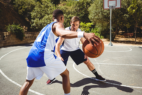 Friends playing basketball in court