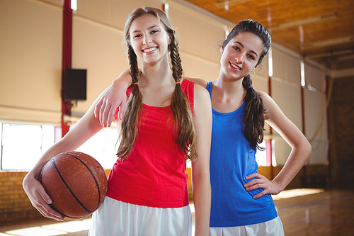 Portrait of happy female basketball players standing in court