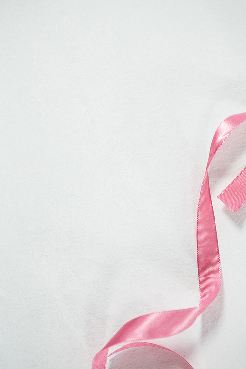 High angle view of pink ribbon for Breast Cancer Awareness on white background