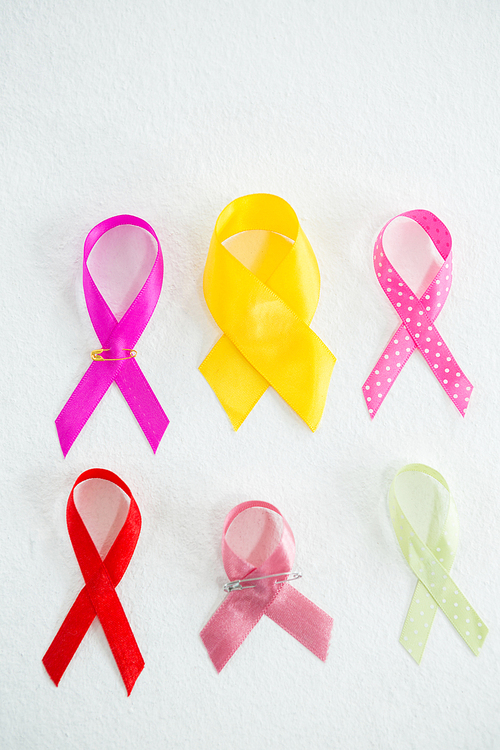Overhead view of various awareness ribbons on white background
