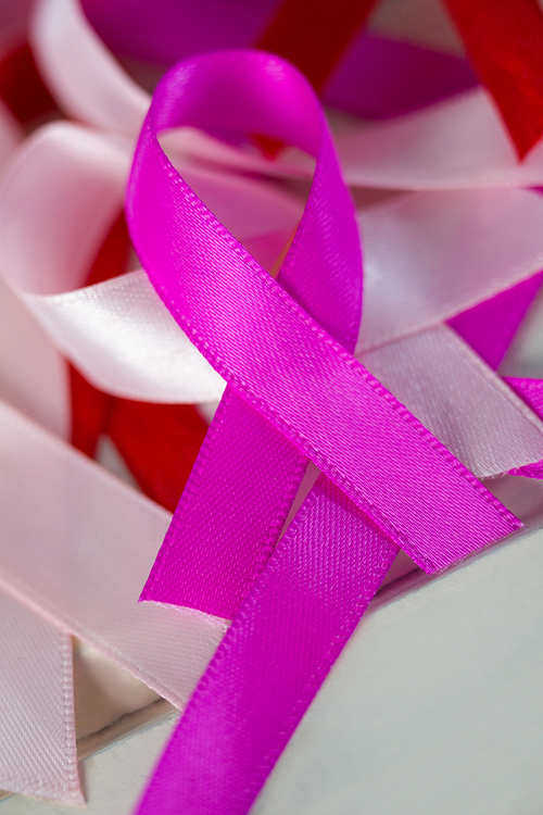 Close-up of various Cancer Awareness ribbons on white wooden table
