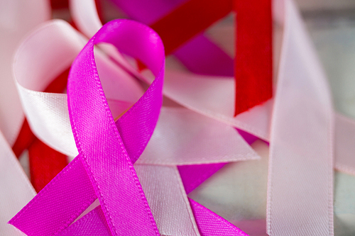 Close-up of Cancer Awareness ribbons on white wooden table