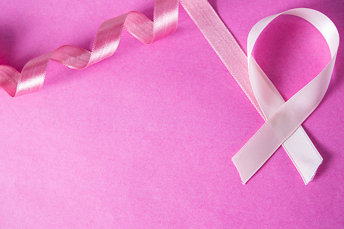 Overhead view of Breast Cancer ribbon against pink background