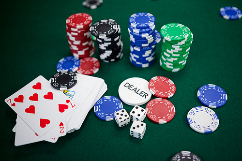 Playing cards, dices and casino chips on poker table in casino