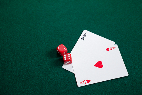 Pair of dice and playing cards on poker table in casino