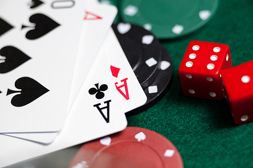 Close-up of playing cards, dices and casino chips on poker table