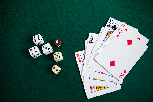 Playing cards and dices on poker table in casino