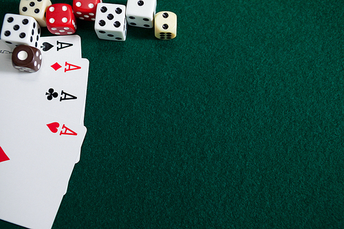 Various dice and playing cards on poker table in casino