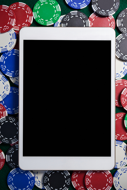 Close-up of digital tablet on multicolored casino chips