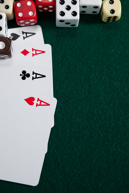 Various dice and playing cards on poker table in casino