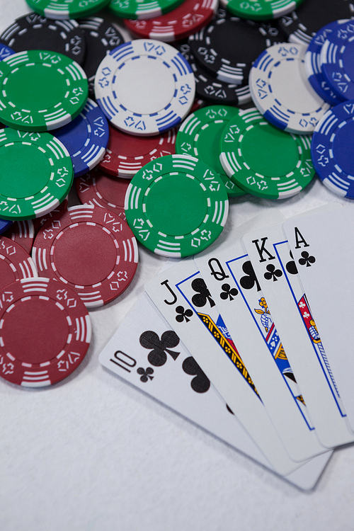 Close-up of playing cards and casino chips on white background