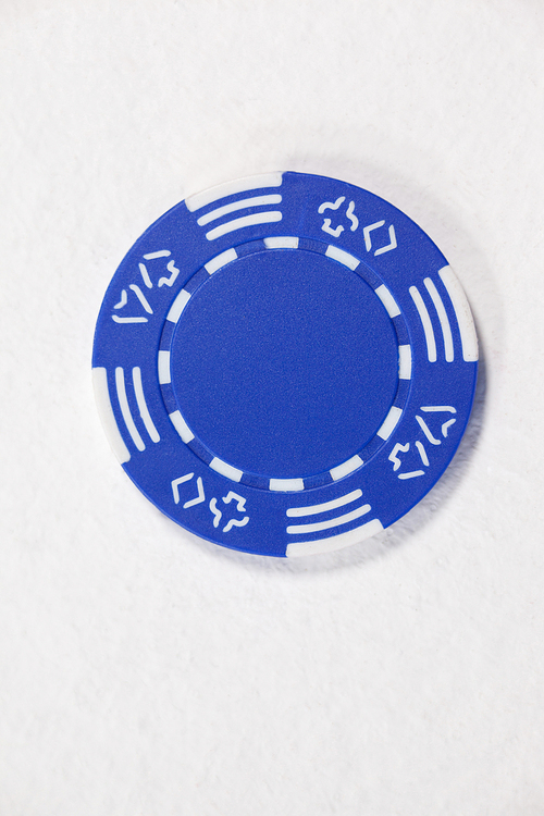 Close-up of blue casino chip on white background