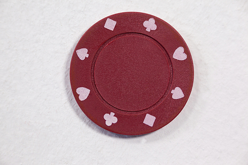 Close-up of red casino chip on white background