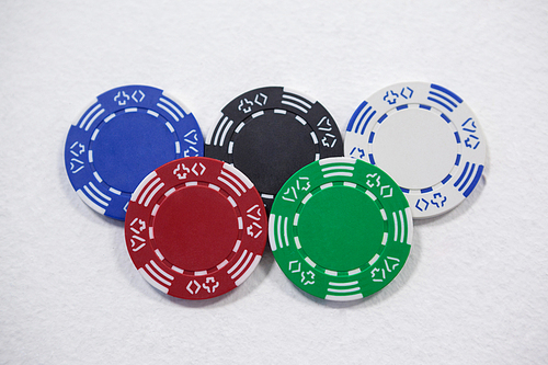 Various casino chips arranged on white background