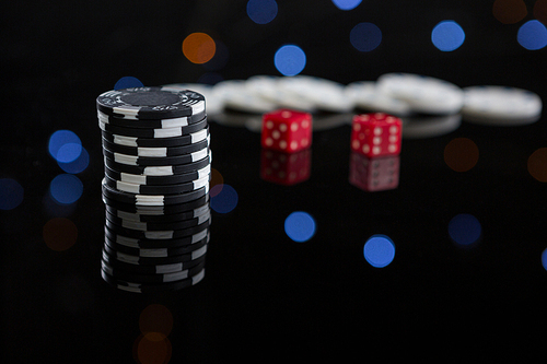 Close-up of chips stacks and dices on table at casino