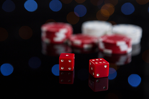 Close-up of red dices with chips on table