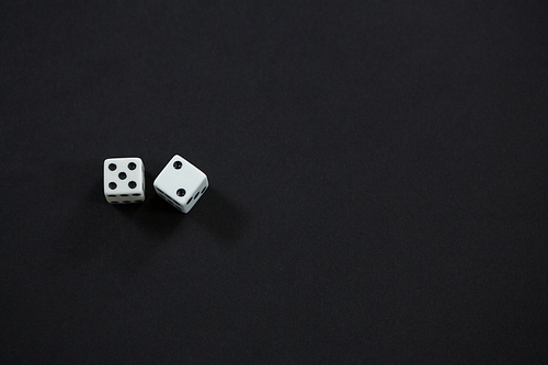 High angle view of white dices on black background