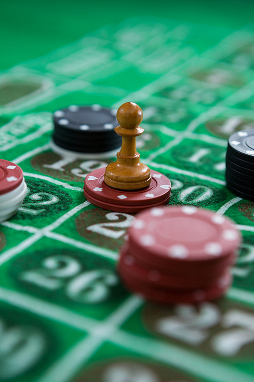 Close-up of coin and chips on roulette table