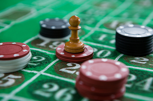 Close-up of coin and chips on roulette table at casino