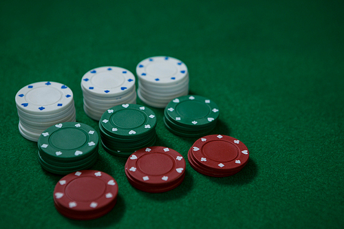 High angle view of poker chips on green table