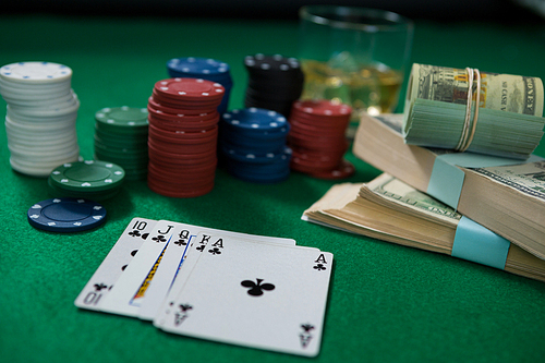 Close-up of whisky and money during poker game on green table