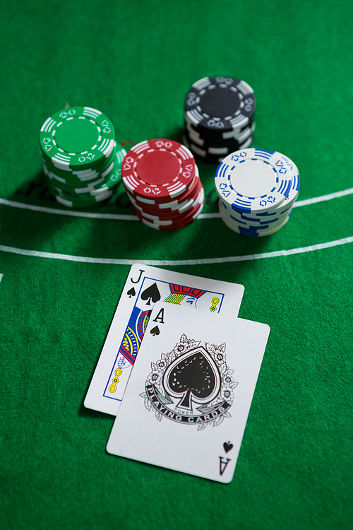 High angle view of spades cards with chips on blackjack table