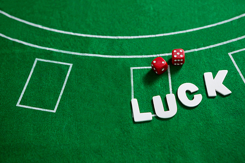 Close-up of text and red dices on blackjack table