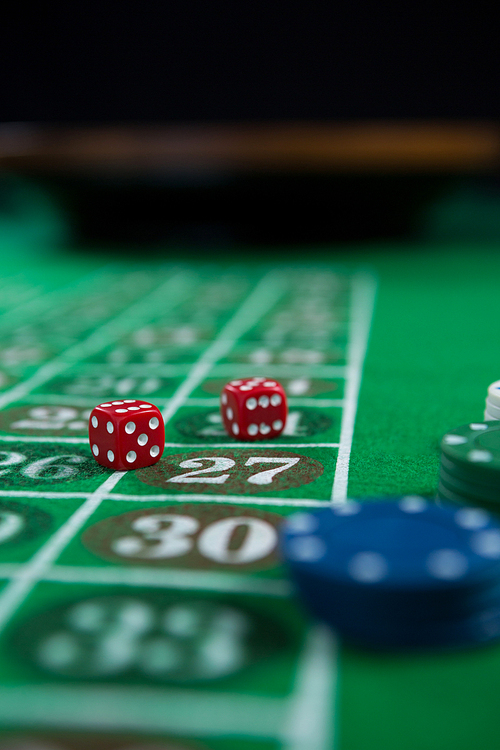 Close-up of dices and chips on roulette table