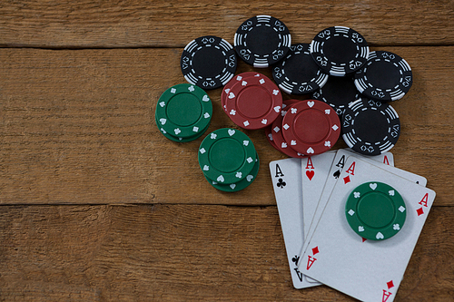 Overhead view of aces and chips on wooden table