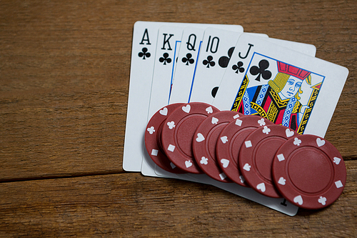 Overhead view of cards and maroon chips on wooden table