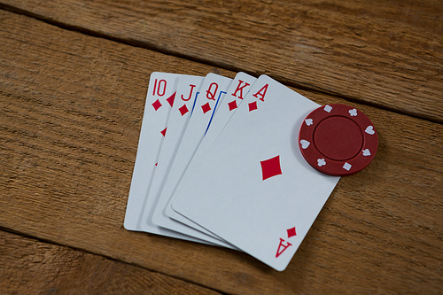 High angle view of cards and chip on wooden table