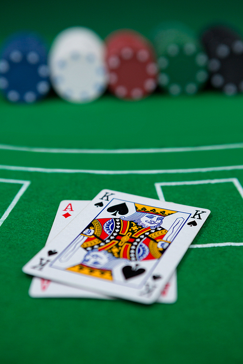 Close-up of cards and chips on blackjack table at casino