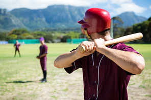 Players playing baseball while standing on field