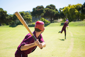 Baseball players playing together on field during sunny day