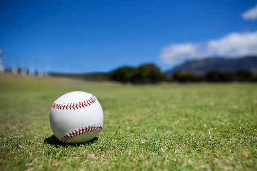 Ball on baseball field against blue sky