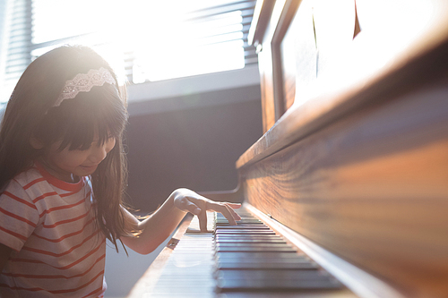 Elementary girl practicing piano in class at music school