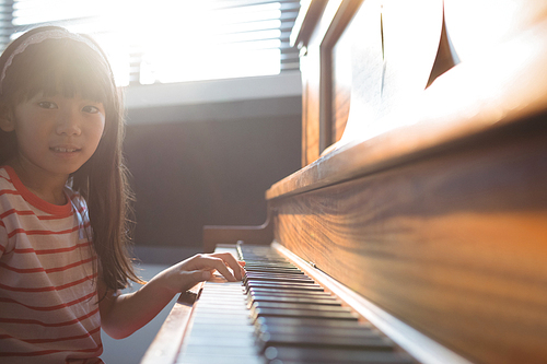 Portrait of girl practicing piano in class at music school