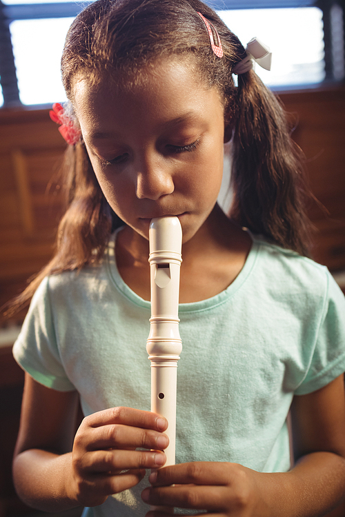 Girl playing flute in classroom at music school